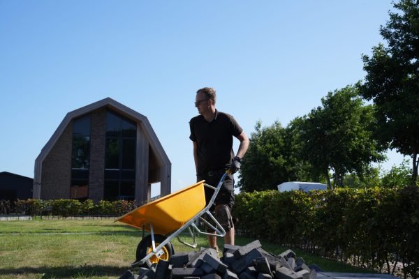 koen-kruiwagen-actie-1 Actiefoto van Koen tijdens hovenierswerk