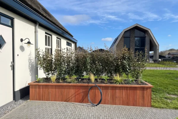 Hardhouten plantenbak bij moderne woning