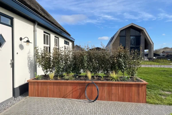 Hardhouten plantenbak bij moderne woning