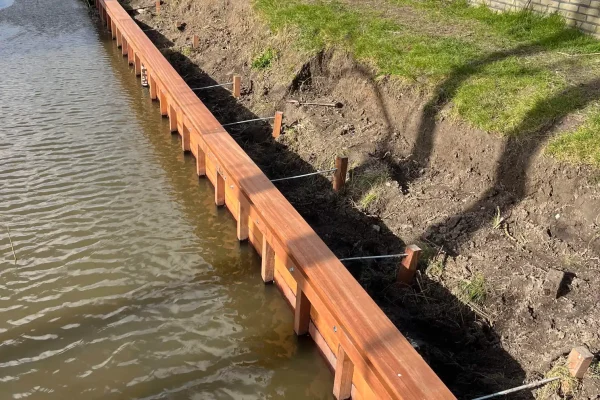 Lange houten beschoeiing langs sloot