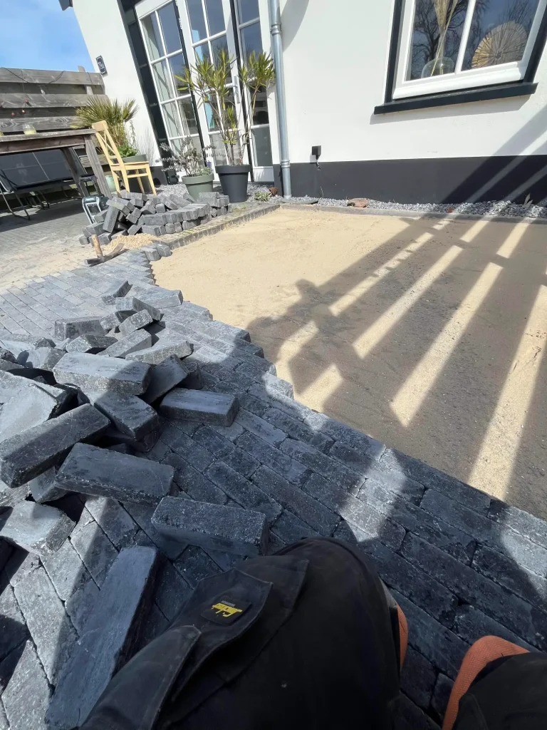 Zandbed voorbereiden voor terras met klinkers