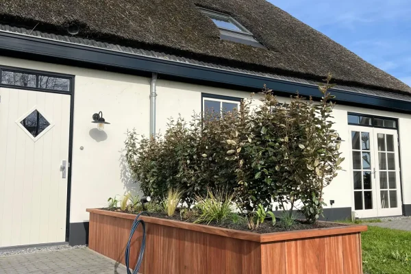 Hardhouten plantenbak bij moderne woning